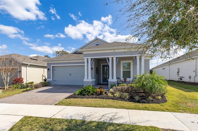 view of front of house with a garage, covered porch, and a front lawn