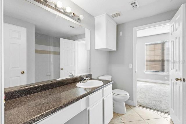 bathroom featuring vanity, toilet, walk in shower, and tile patterned floors