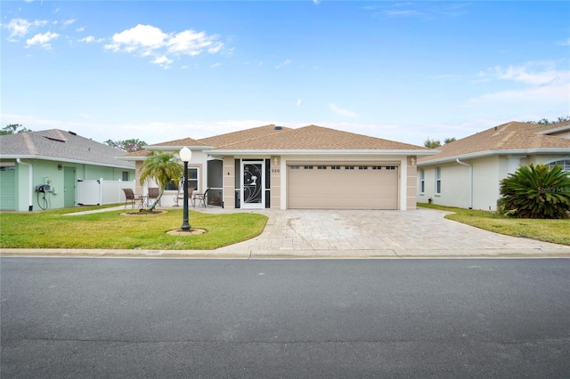 single story home featuring a garage and a front lawn