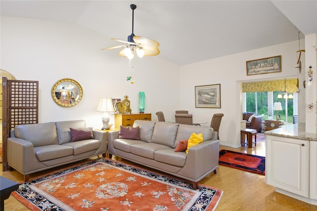 living room with ceiling fan, high vaulted ceiling, and light wood-type flooring