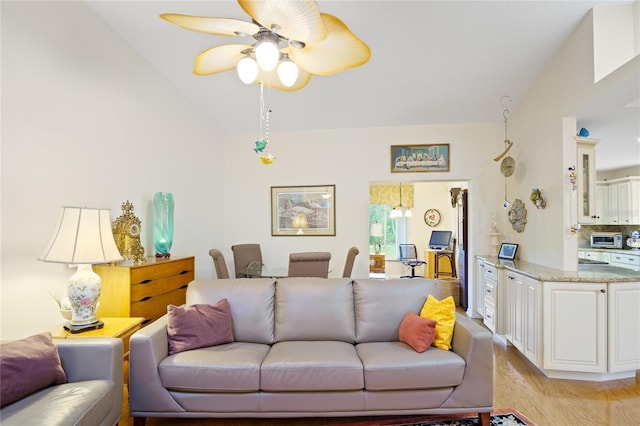 living room featuring vaulted ceiling, ceiling fan, and light hardwood / wood-style floors