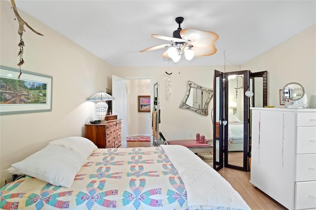 bedroom featuring ceiling fan, light hardwood / wood-style floors, and a baseboard heating unit