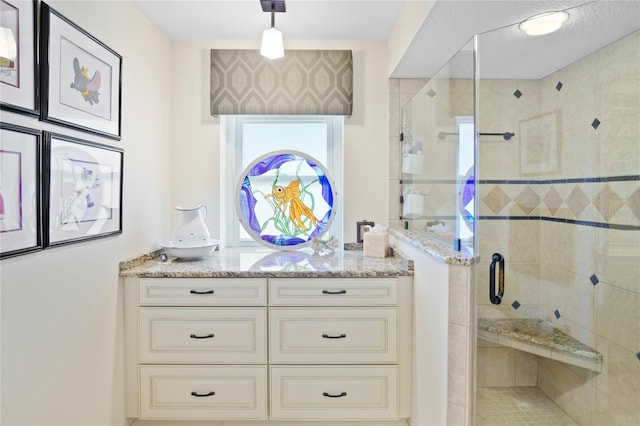 bathroom with vanity and a shower with door