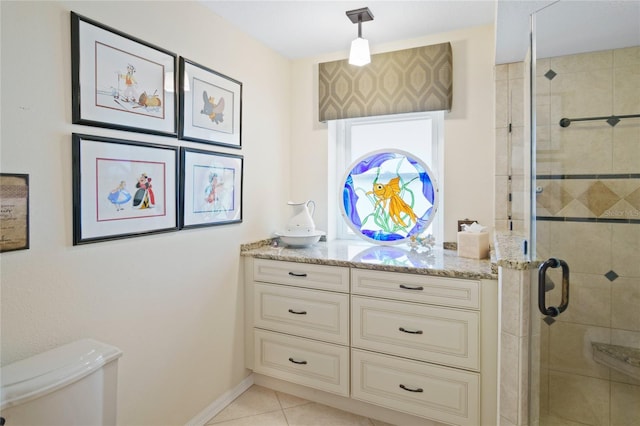 bathroom featuring tile patterned flooring, vanity, toilet, and walk in shower