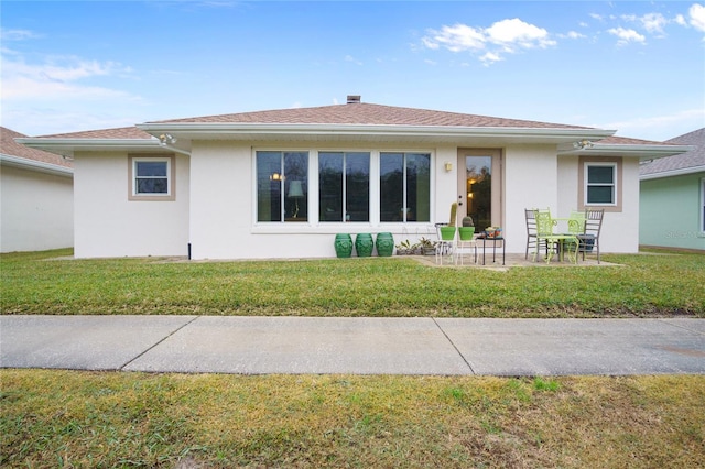 rear view of house with a patio and a lawn