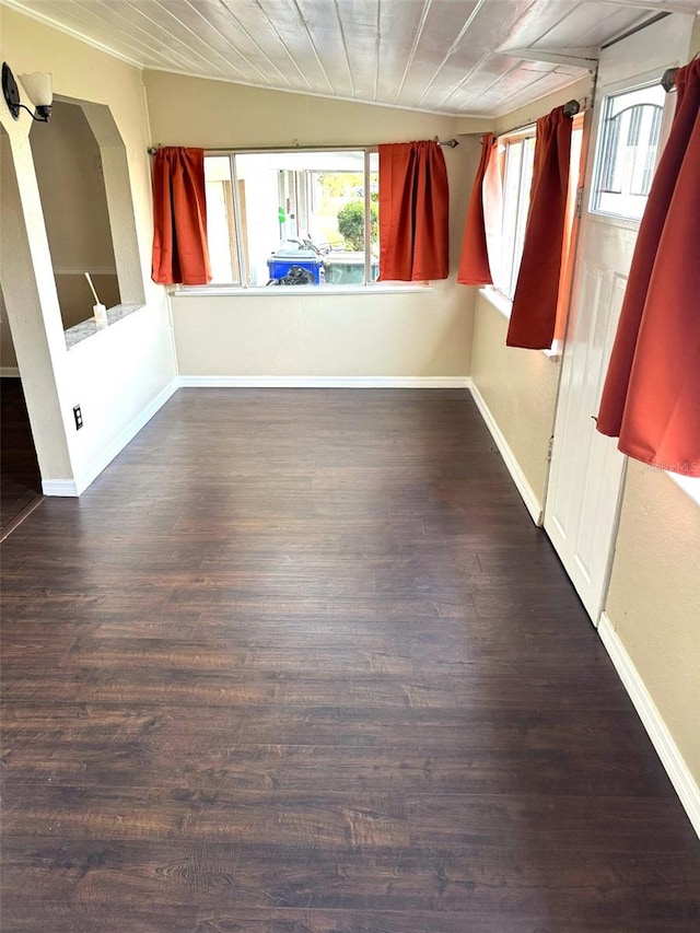 spare room with dark wood-type flooring, wooden ceiling, and a wealth of natural light