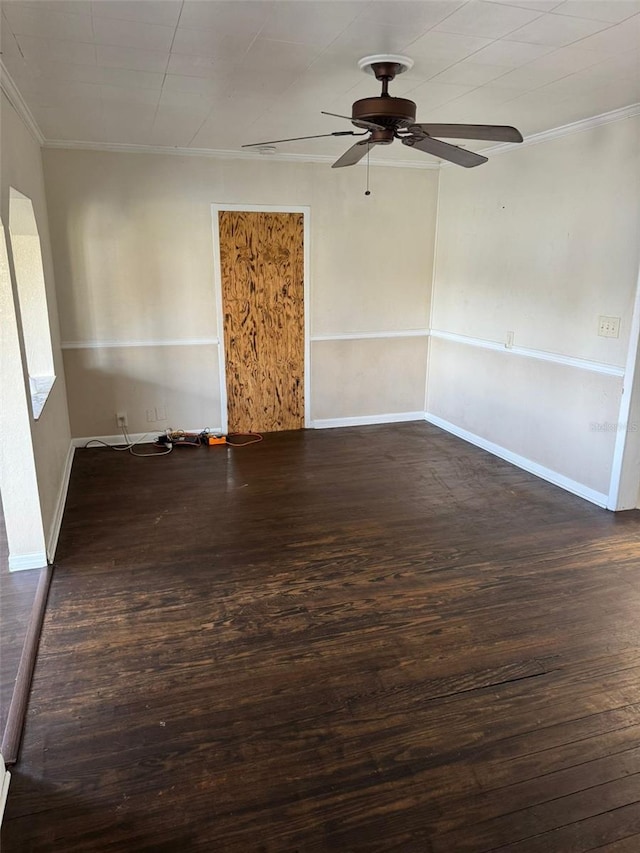 spare room with crown molding, baseboards, ceiling fan, and wood finished floors