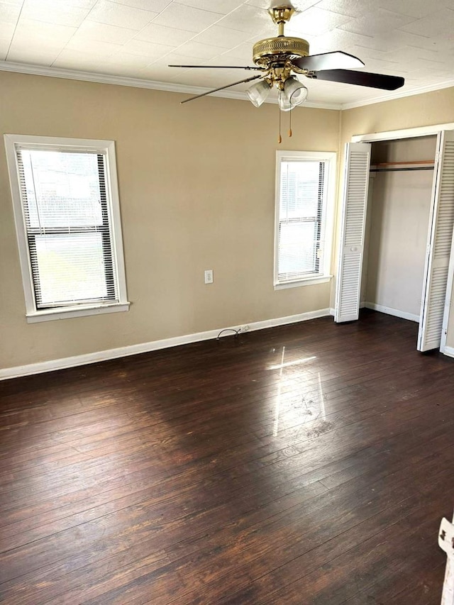 unfurnished bedroom featuring crown molding, ceiling fan, dark hardwood / wood-style flooring, and a closet