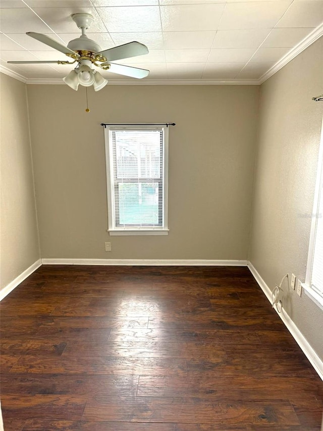 empty room with dark wood-style floors, crown molding, baseboards, and ceiling fan