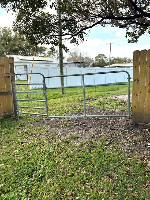 view of gate with a yard