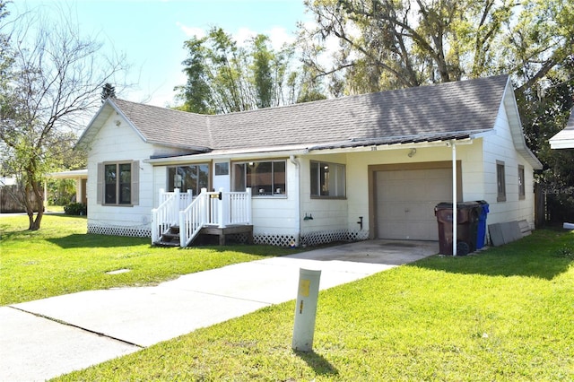 ranch-style house featuring a shingled roof, a front yard, concrete driveway, and a garage