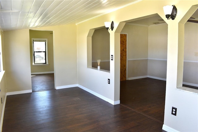 empty room with wooden ceiling, dark wood finished floors, and baseboards