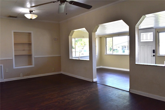 unfurnished room featuring built in features, baseboards, ornamental molding, and wood finished floors