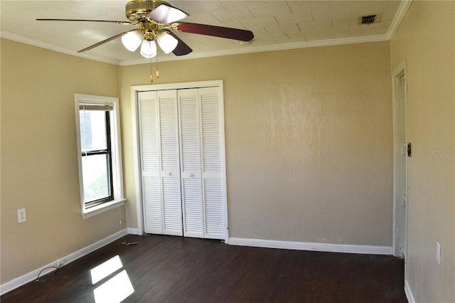 unfurnished bedroom with dark wood-style floors, baseboards, visible vents, and ornamental molding