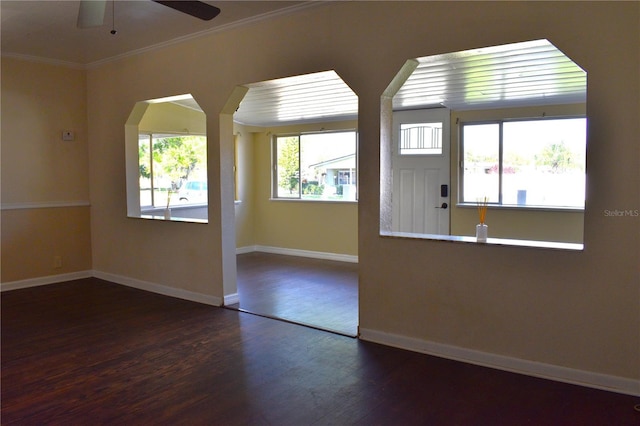 unfurnished room with ceiling fan, crown molding, baseboards, and wood finished floors