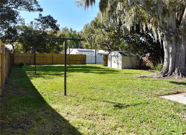 view of yard with a storage shed, an outdoor structure, and a fenced backyard