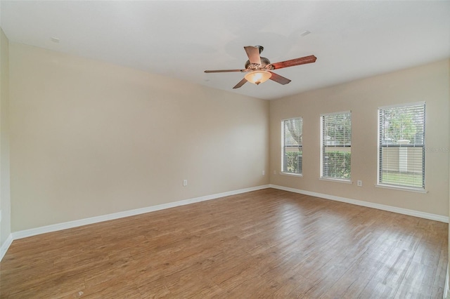 empty room with ceiling fan and light hardwood / wood-style flooring