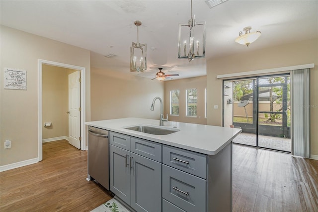 kitchen with sink, hanging light fixtures, a center island with sink, dishwasher, and hardwood / wood-style flooring