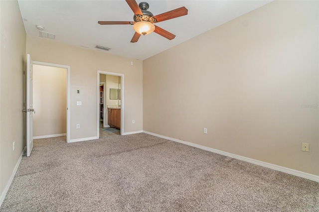 unfurnished bedroom with connected bathroom, light carpet, and ceiling fan