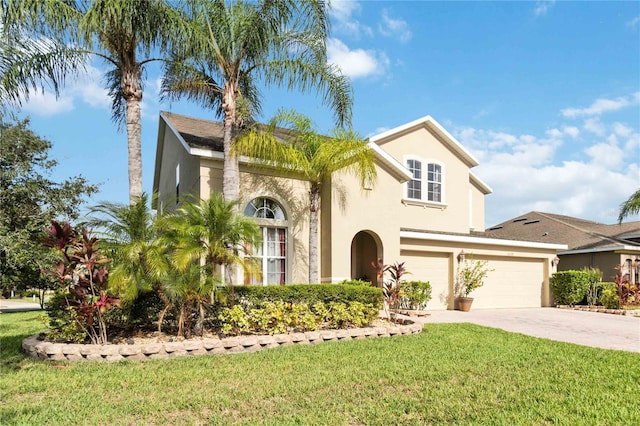 mediterranean / spanish home with a garage and a front lawn