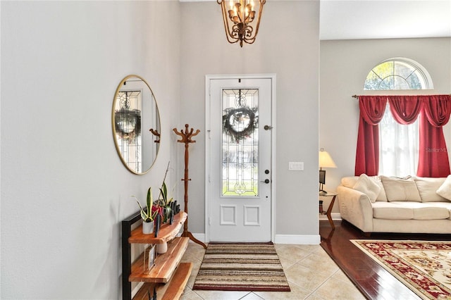 tiled foyer with a notable chandelier and a towering ceiling