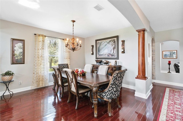 dining area with dark hardwood / wood-style flooring, a chandelier, and decorative columns