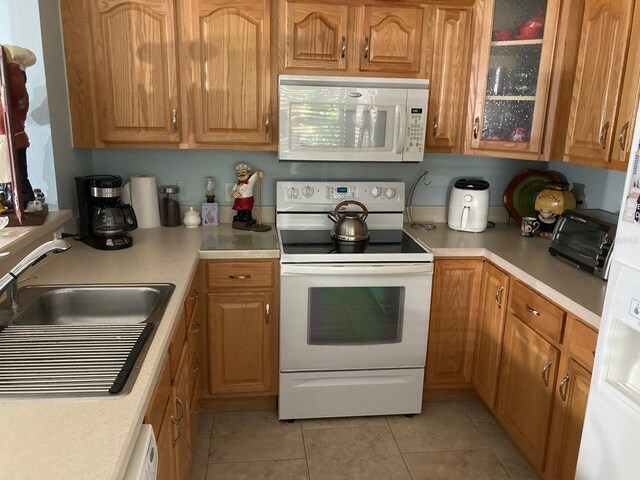 kitchen with sink, white appliances, and light tile patterned floors