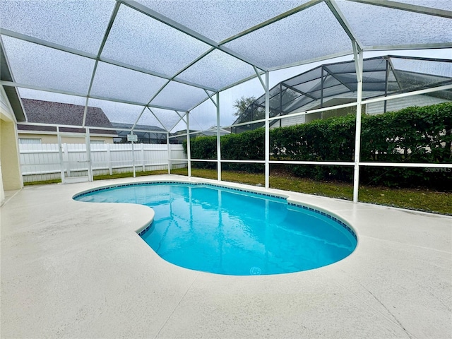 view of swimming pool with a patio and glass enclosure