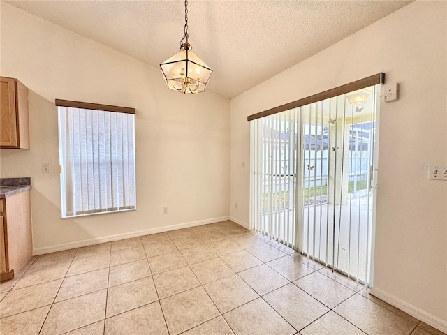 unfurnished dining area featuring light tile patterned flooring, a chandelier, and a textured ceiling