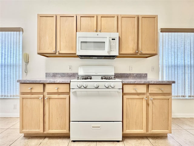 kitchen featuring light tile patterned flooring, white appliances, and light brown cabinetry