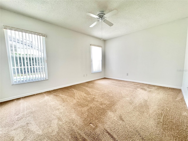 spare room featuring ceiling fan, a textured ceiling, and carpet floors