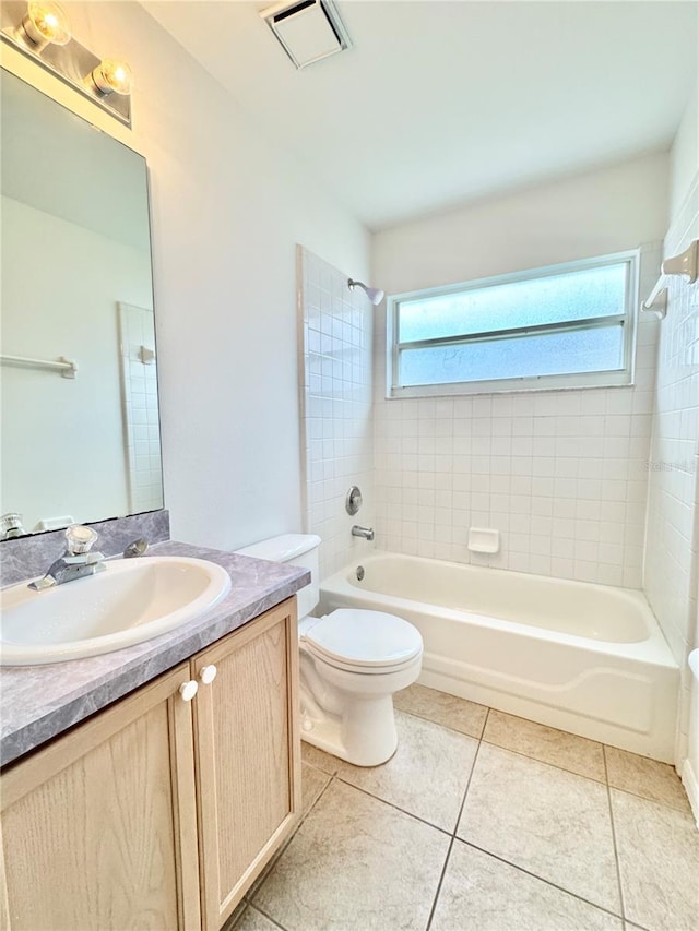 full bathroom featuring vanity, toilet, tiled shower / bath, and tile patterned flooring