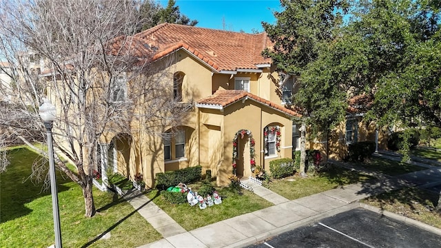 mediterranean / spanish-style house with a front lawn