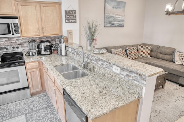 kitchen featuring appliances with stainless steel finishes, sink, light brown cabinets, and kitchen peninsula