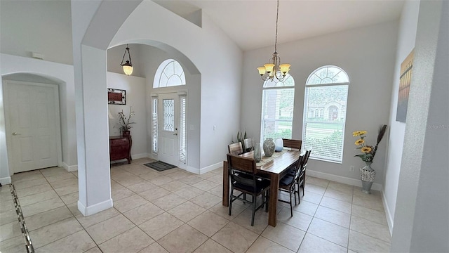 tiled dining space featuring lofted ceiling and a chandelier