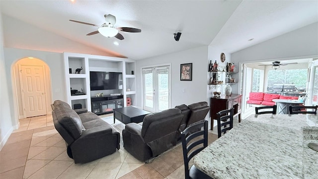 living room with built in shelves, vaulted ceiling, plenty of natural light, and light tile patterned flooring