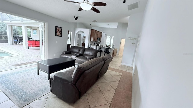 tiled living room featuring ceiling fan and a textured ceiling