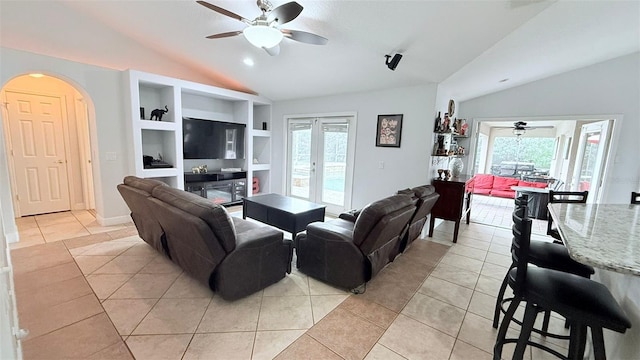 living room with ceiling fan, french doors, built in features, light tile patterned flooring, and lofted ceiling