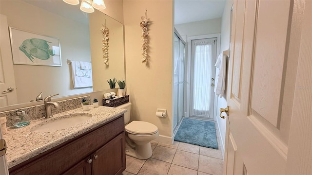 bathroom featuring tile patterned floors, a shower with door, toilet, and vanity