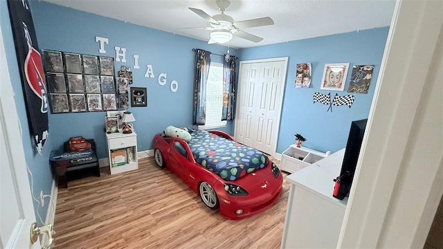 bedroom with hardwood / wood-style flooring, a closet, and ceiling fan