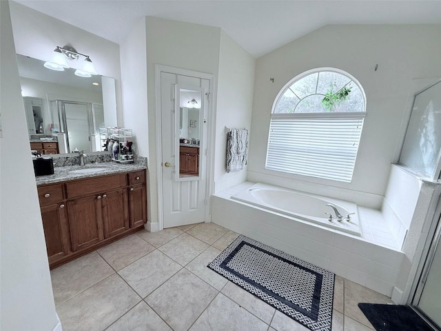 bathroom featuring vanity, lofted ceiling, independent shower and bath, and tile patterned flooring