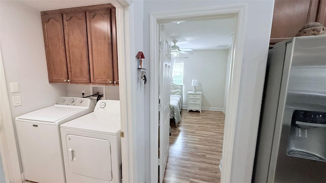 washroom with washing machine and clothes dryer, ceiling fan, light hardwood / wood-style flooring, and cabinets