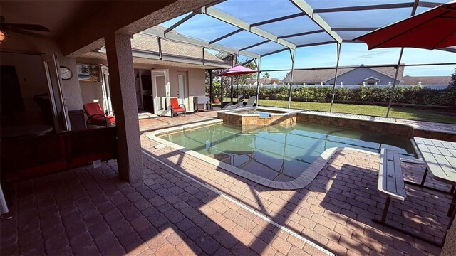 view of swimming pool featuring an in ground hot tub, a lanai, and a patio area