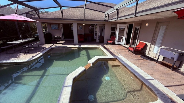 view of swimming pool with glass enclosure and a patio area