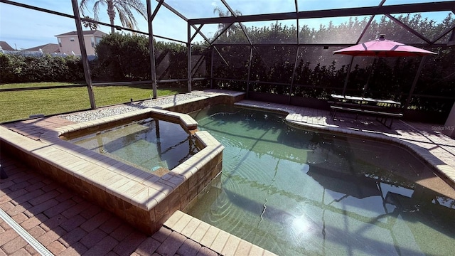 view of pool featuring an in ground hot tub, a patio area, glass enclosure, and a lawn