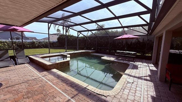 view of swimming pool featuring glass enclosure, an in ground hot tub, and a patio