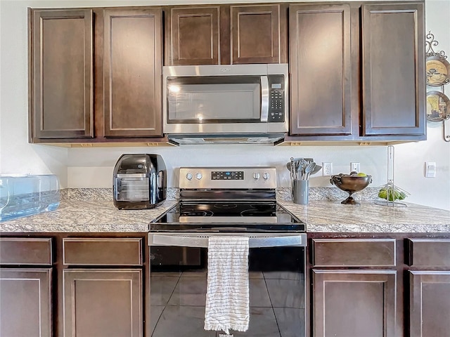 kitchen featuring stainless steel appliances and dark brown cabinetry