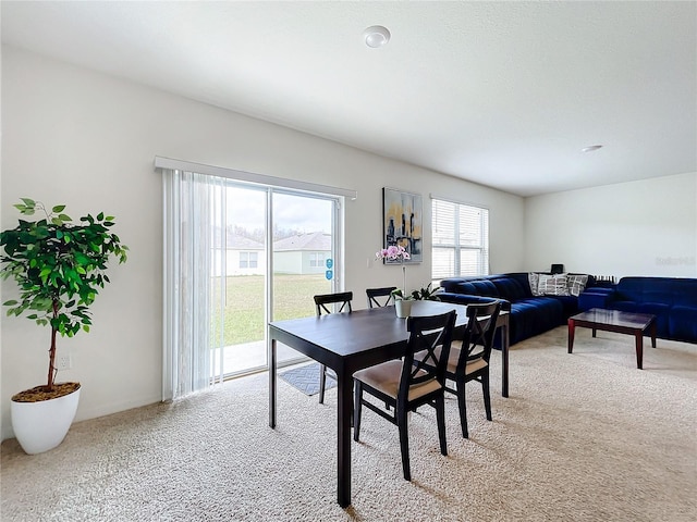 dining area featuring light carpet