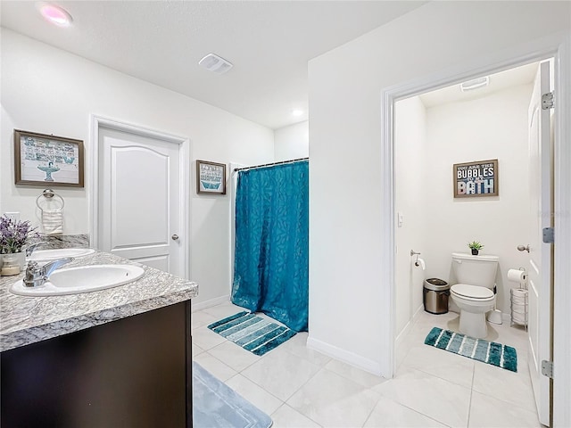 bathroom with curtained shower, toilet, vanity, and tile patterned flooring