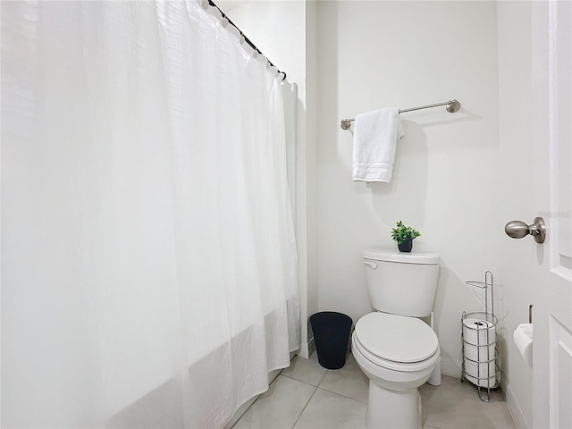 bathroom with shower / bath combination with curtain, toilet, and tile patterned flooring